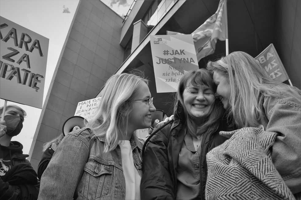 Back-and-white photo of protesters at a pro-abortion march in Poland, including three members of ​the Aborcyjny Dream Team