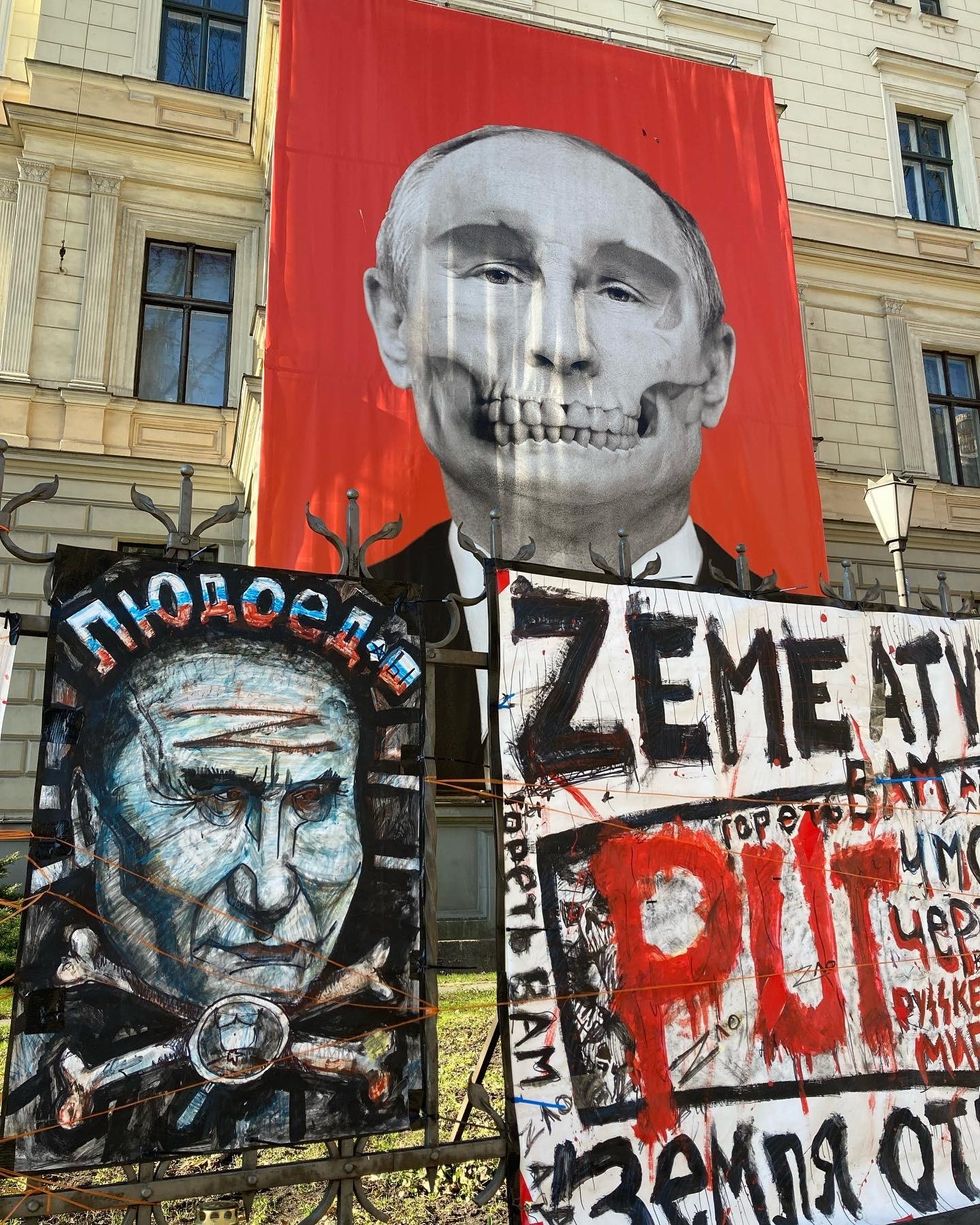 Banner adorned with the portrait of Vladimir Putin with a grimacing jaw of a skull and crossbones.