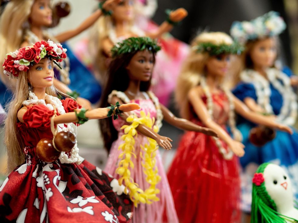 Barbie dolls dancing in floral dresses.