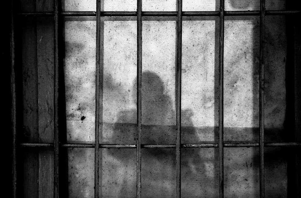 Black and white photo of a silhouette in a prison cell