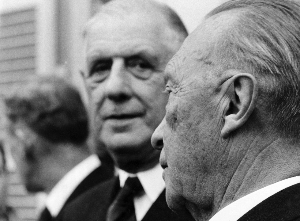 Black and white photo of French President Charles de Gaulle looking at German Chancellor Konrad Adenauer in Bohn, Germany, in 1961.