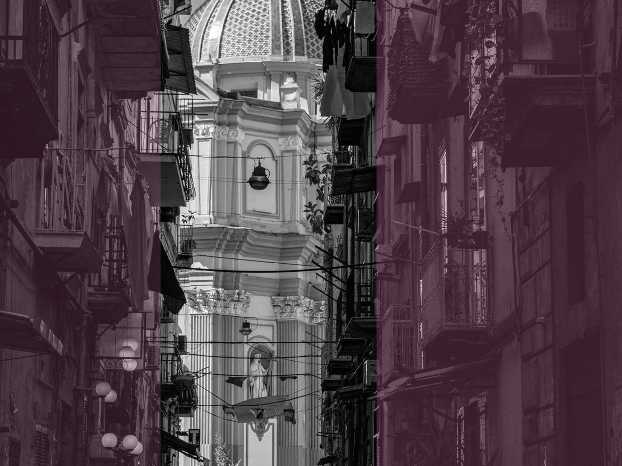 black and white photograph of a woman walking down a Neapolitan street, towards a large church.