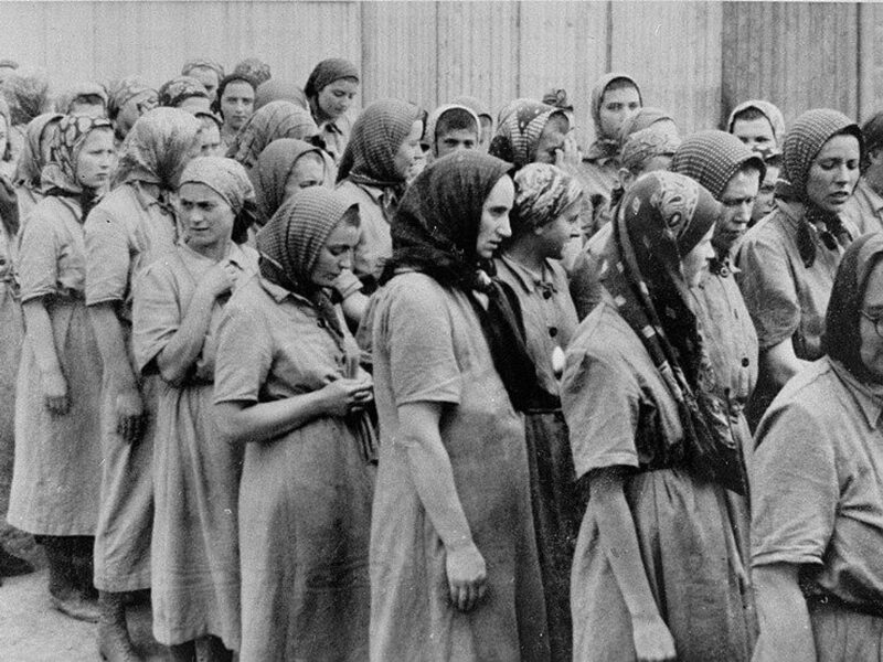 Black-and-white photograph of ​Jewish women waiting in line at Auschwitz-Birkenau in 1944