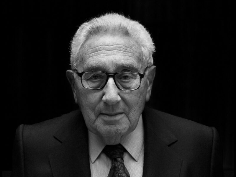 Black and white photograph of Henry Kissinger wearing a suit and glasses.
