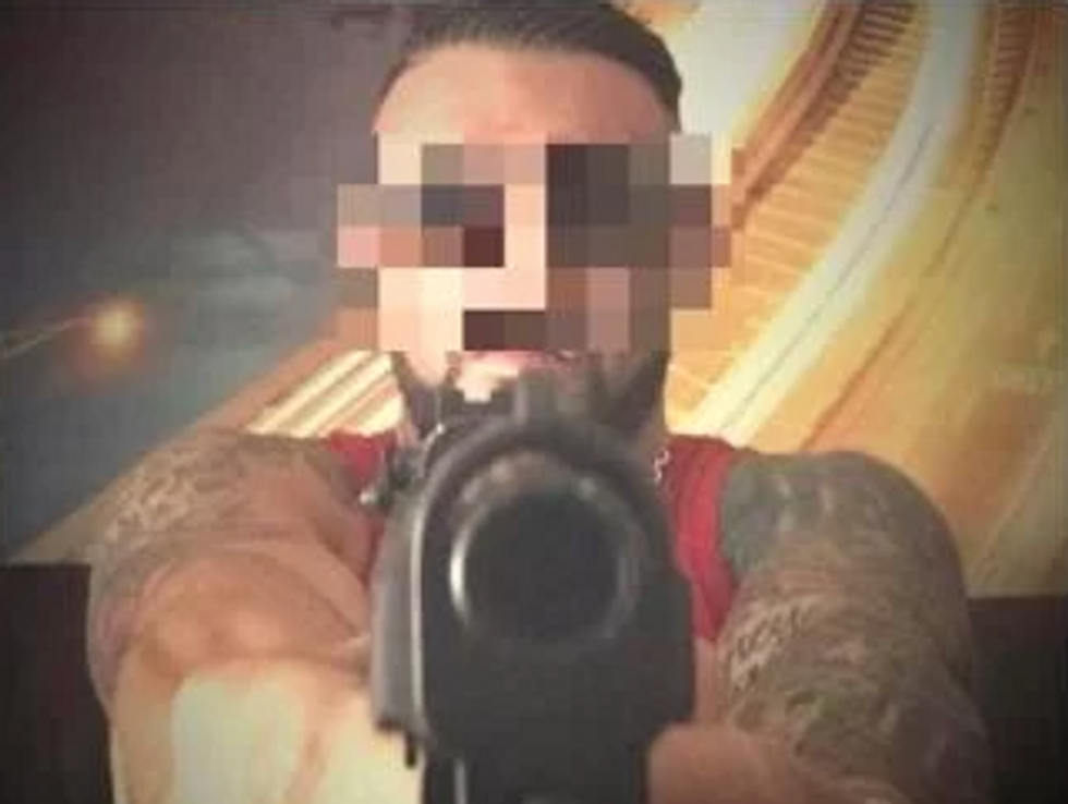 Blurred out screenshot of a TikTok post in which a member of the Italian mafia points his gun at the phone's camera