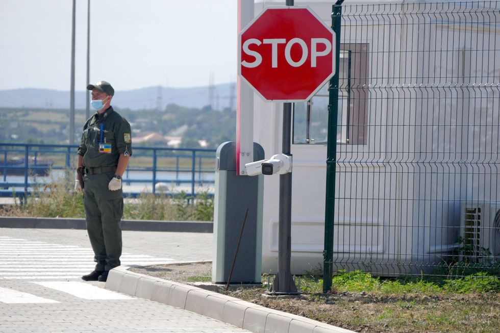 Border guard on the premises of the ferry crossing over the Danube river Orlivka-Isaccea at the international entry point between Ukraine and Romania, Odesa Region, southern Ukraine. ​