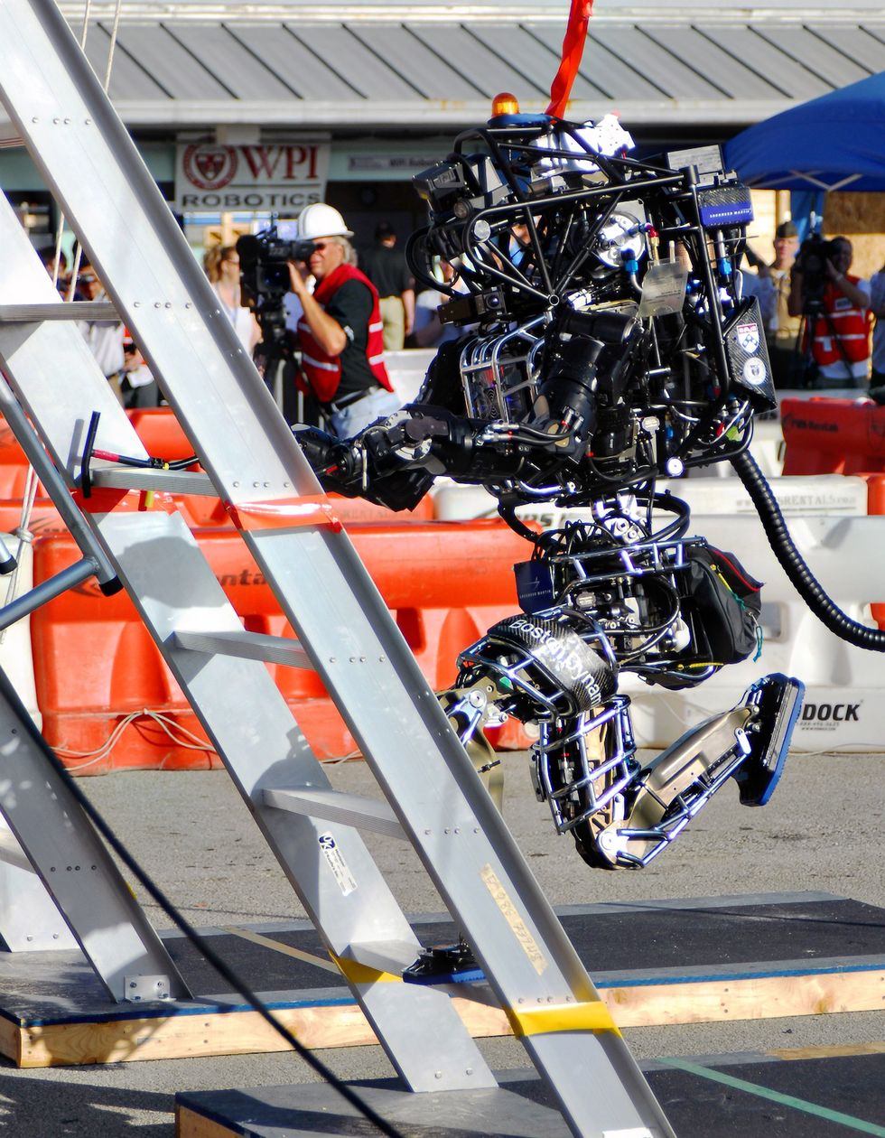 Boston Dynamic's humanoid Atlas robot climbs a ladder as people watch