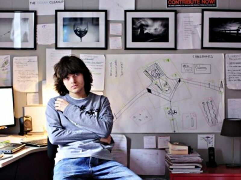 Boyan Slat next to a drawing of his Ocean Cleanup project