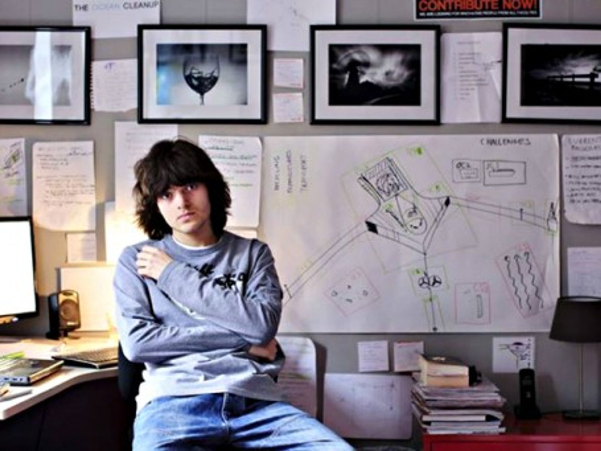 Boyan Slat next to a drawing of his Ocean Cleanup project