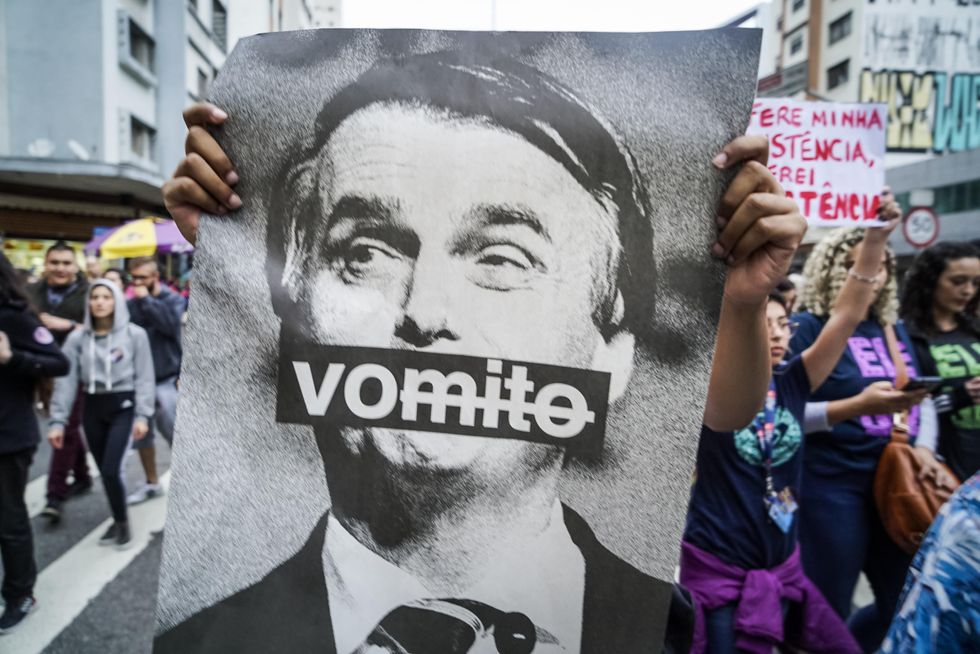 Brazil, Sao Paulo: During a demonstration against the extreme right-wing presidential candidate Bolsonaro, a woman holds up a picture of Bolsonaro with the inscription ''Vomito''.