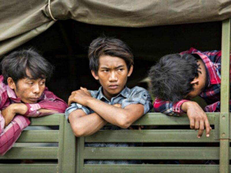 Cambodian migrants wait in an army truck to return home from Thailand.