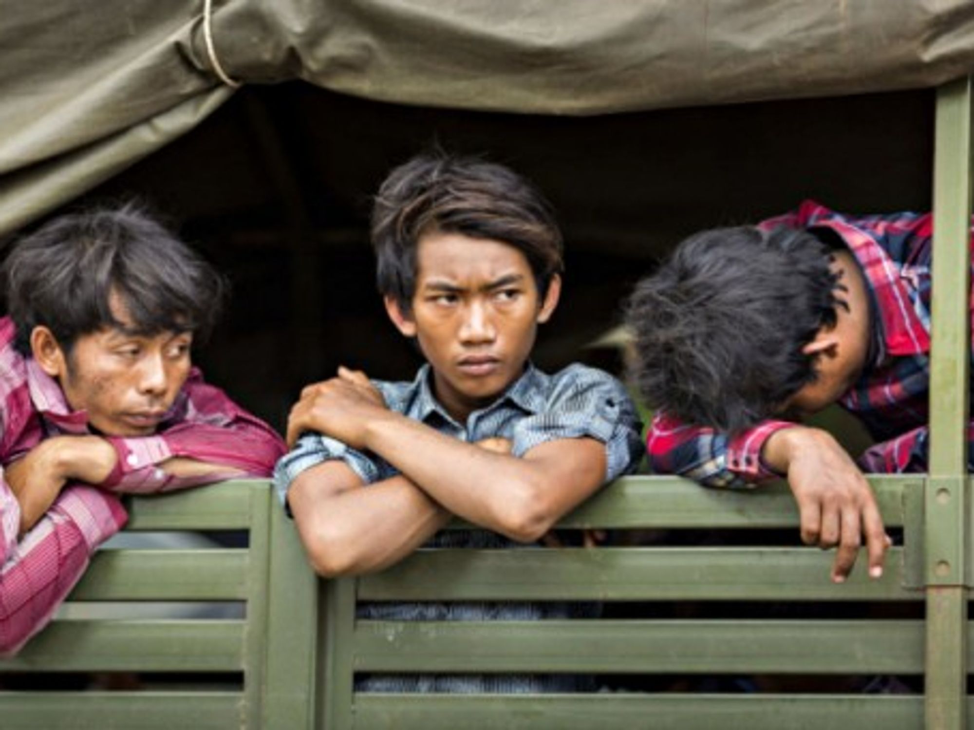 Cambodian migrants wait in an army truck to return home from Thailand.