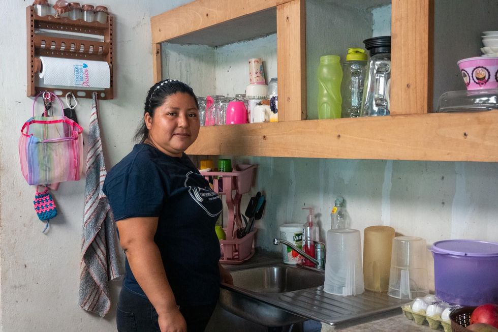 Candelaria Salas Gómez, an orchid rescuer, poses for a portrait in her kitchen in Santa Rita Las Flores, Mapastepec, Chiapas, Mexico.