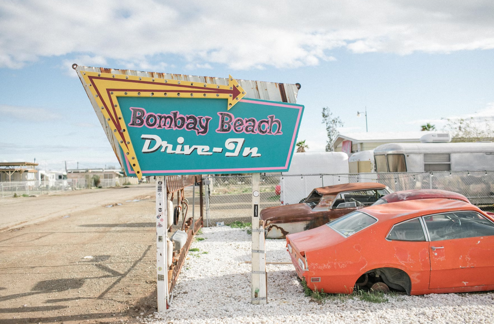 Car parked in front of a sign on California's Bombay Beach.