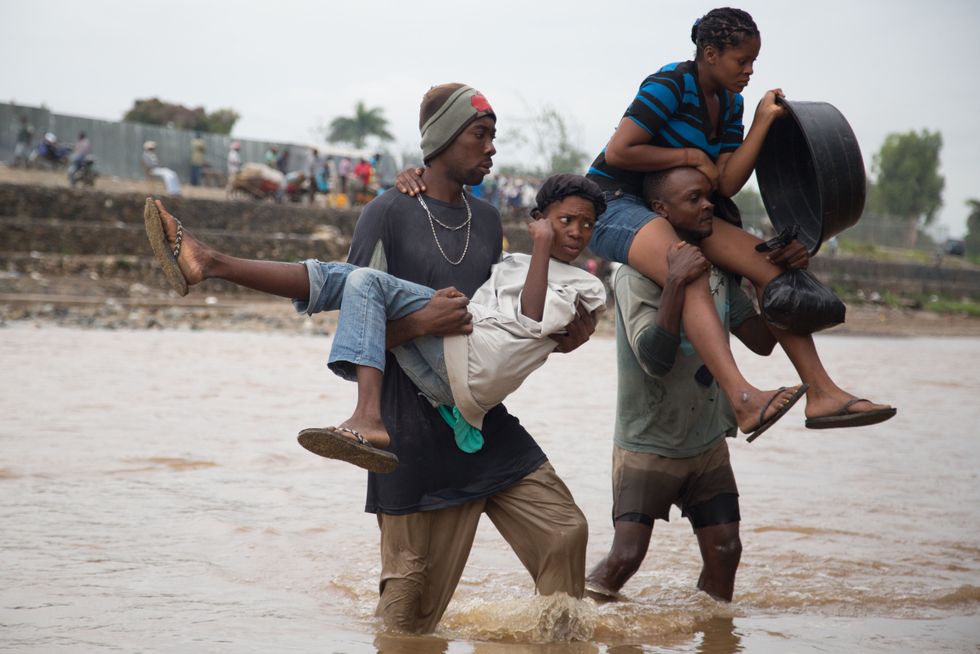 Carrying each other and their belongings, Haitians illegally cross the Massacre river at the Dominican Republic border in Dajabon.