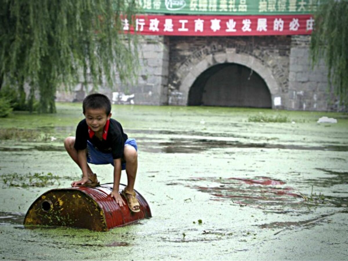 Child playing on garbage floating in the Huai River