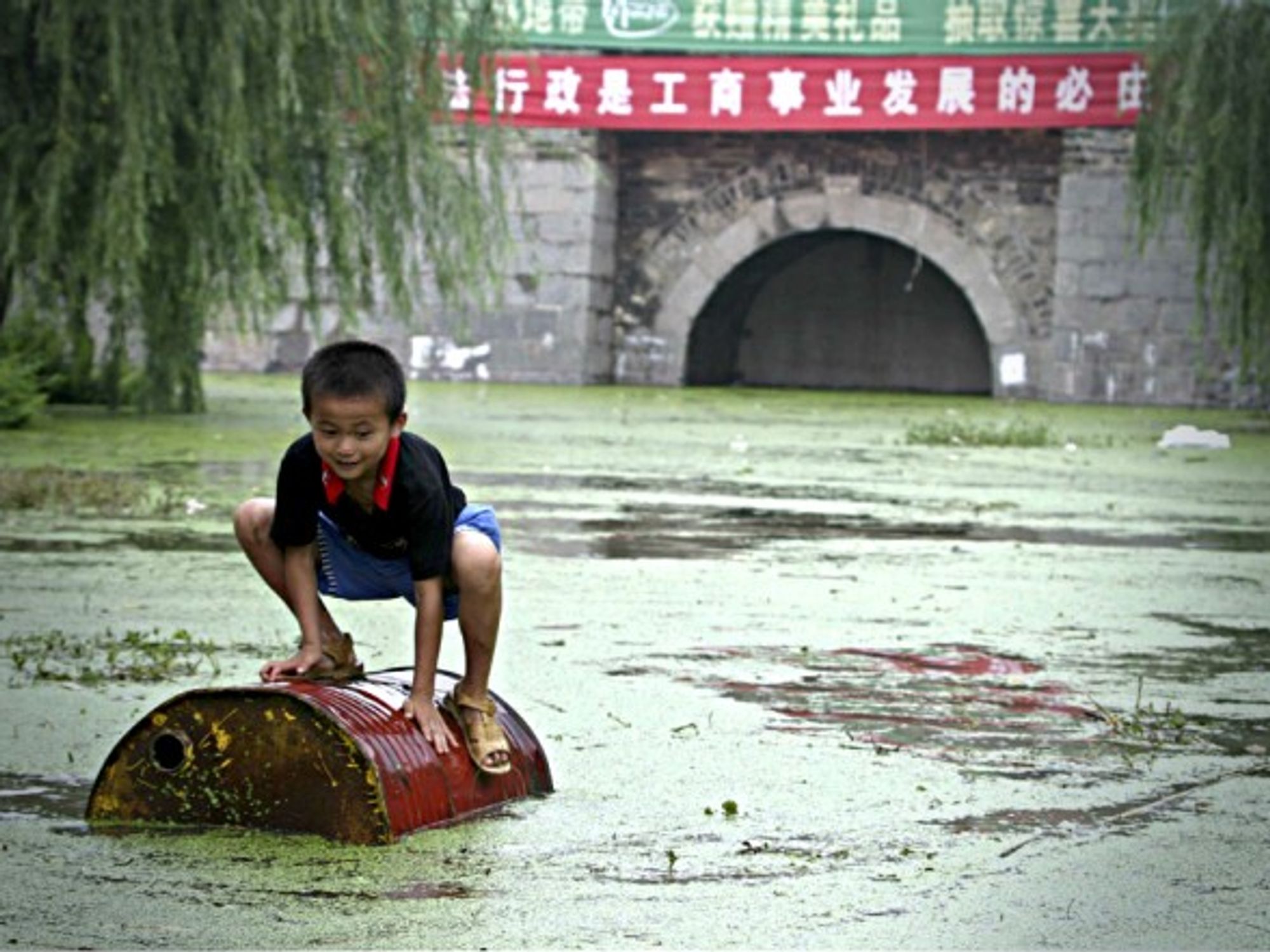 Child playing on garbage floating in the Huai River