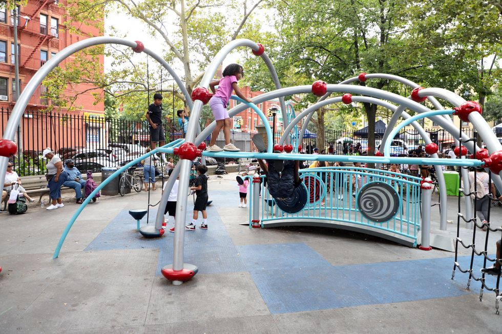 Children having fun in 30th Precinct Carmansville Playground in New York.