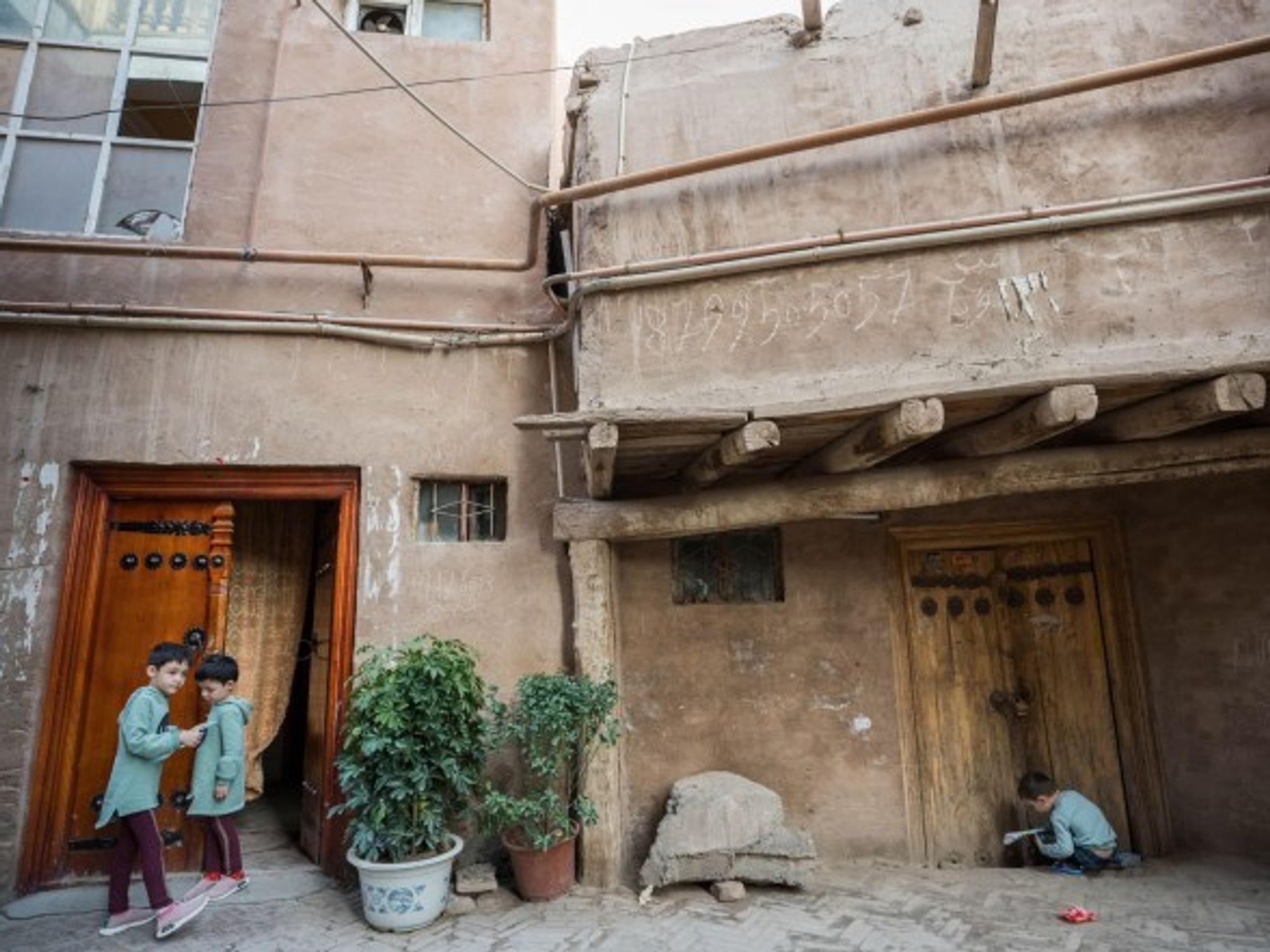 Children outside their traditional Uyghur-style house in Xinjiang