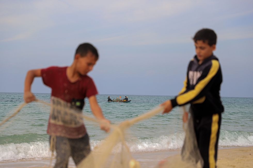 Children prepare fishing net in the southern Gaza Strip city of Khan Younis on Dec. 17, 2023.