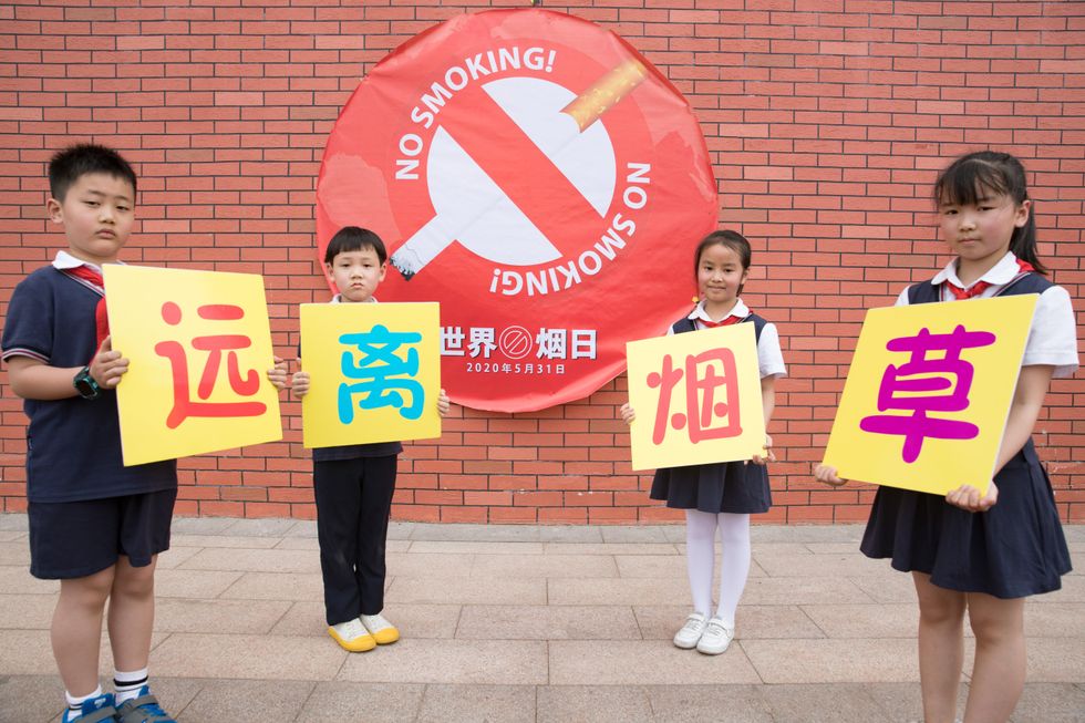 Children standing holding up anti-smoking signs