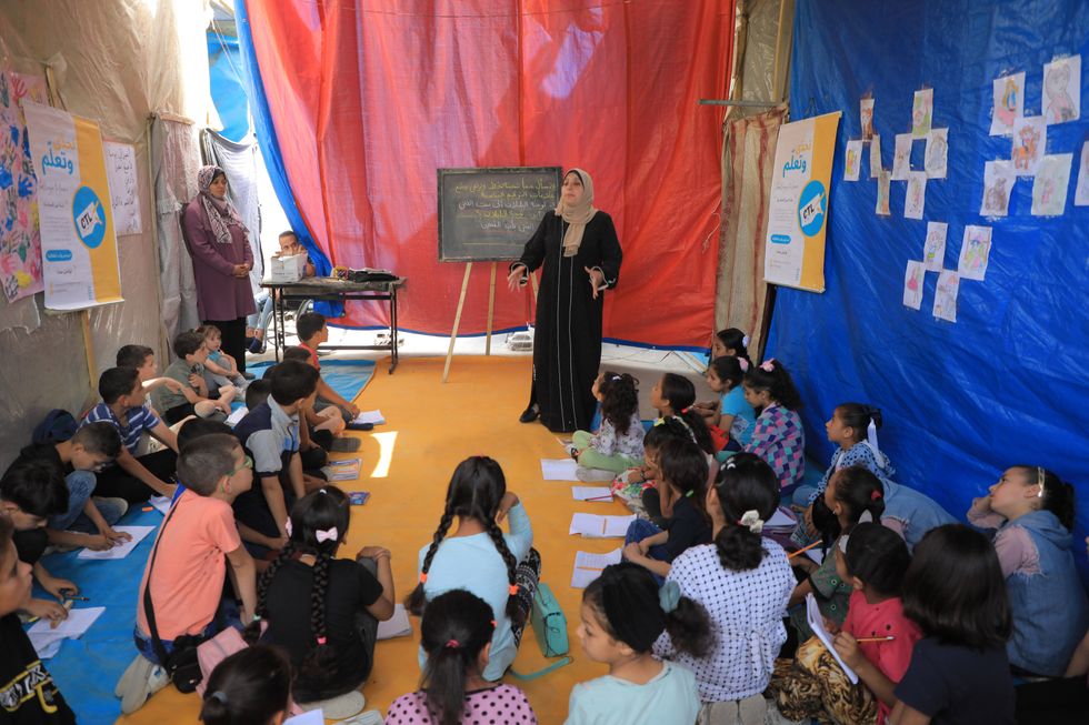 Children study at a temporary school in the city of Deir al-Balah in central Gaza.