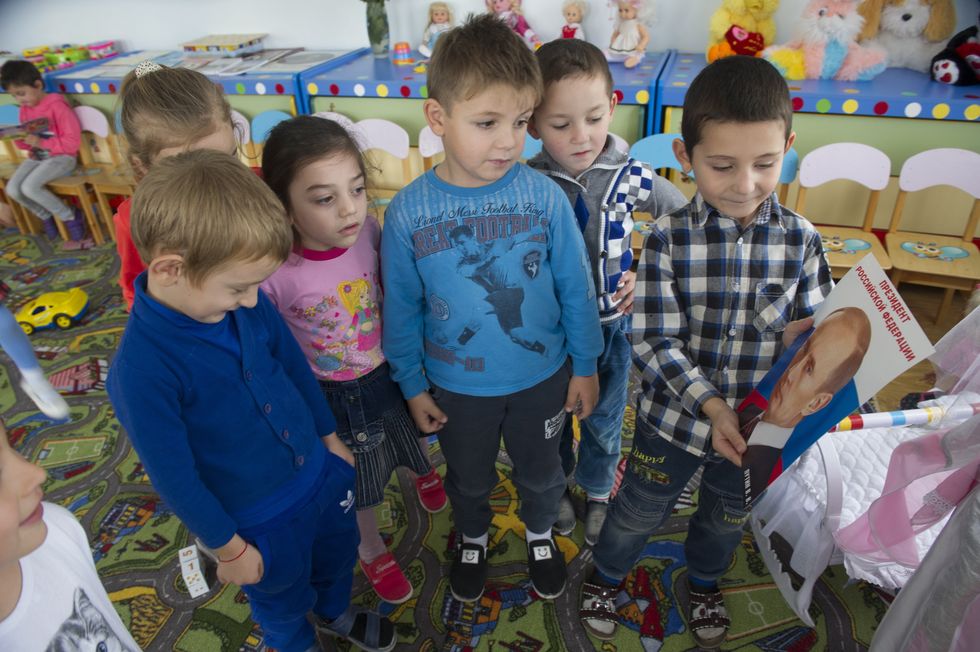 Children with a portrait of Russia's president Vladimir Putin in a kindergarten.