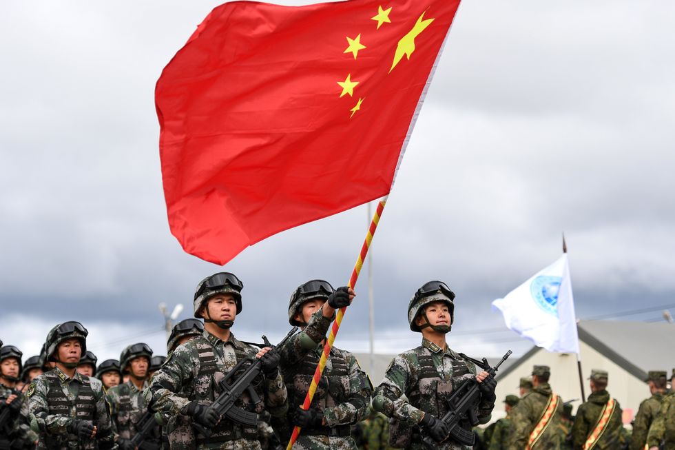 Chinese PLA soldiers march with the national flag at the Peace Mission opening