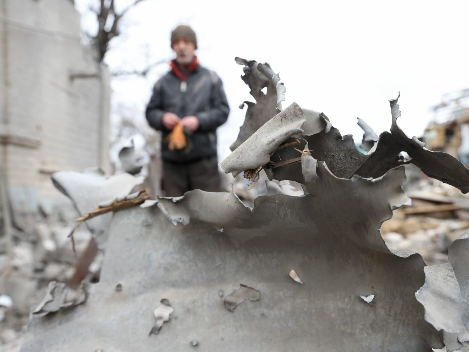 Close up of debris in Melitopol, Ukraine​, with a man standing in the background