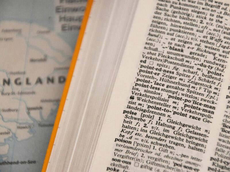 Close-up photo of a dictionary in front of a world map