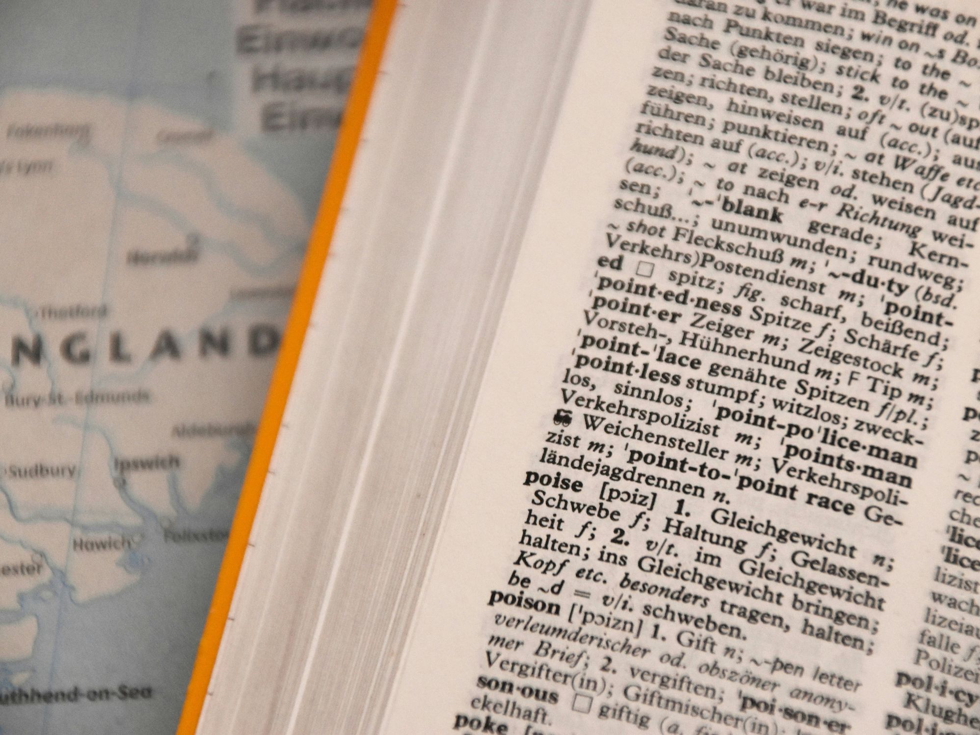 Close-up photo of a dictionary in front of a world map