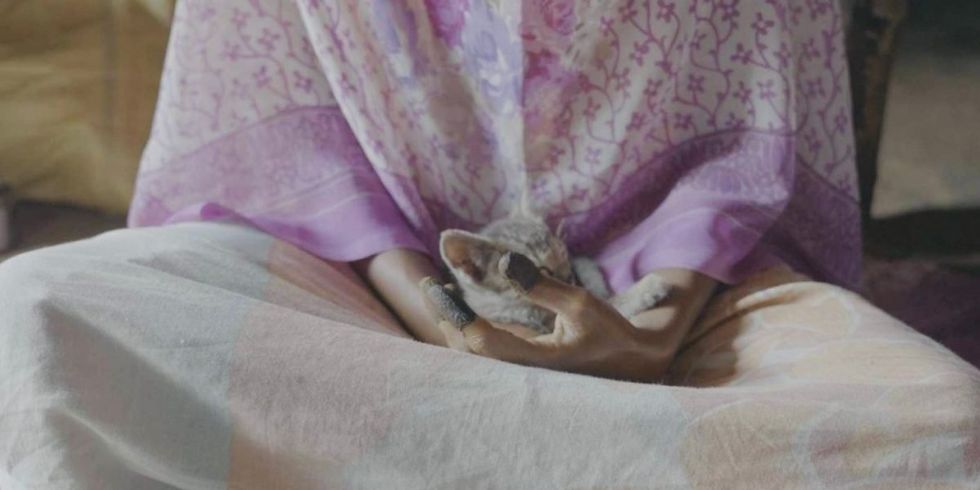 Close up photo of a survivor of the Sumangali Scheme with her pet on her lap.