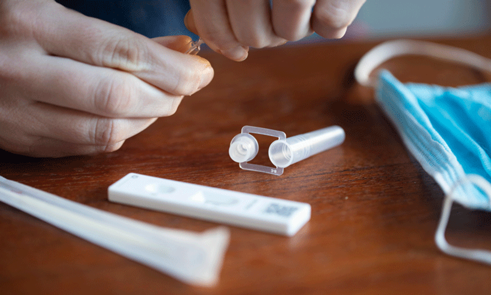 Closeup photo of a person take a COVID-19 lateral flow test