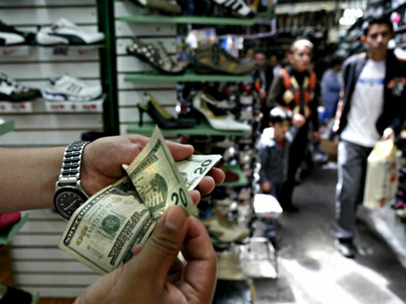 Counting dollar bills in a market in downtown Quito, Ecuador