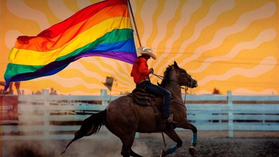 Cowboy proudly waving a pride flag while riding a horse.