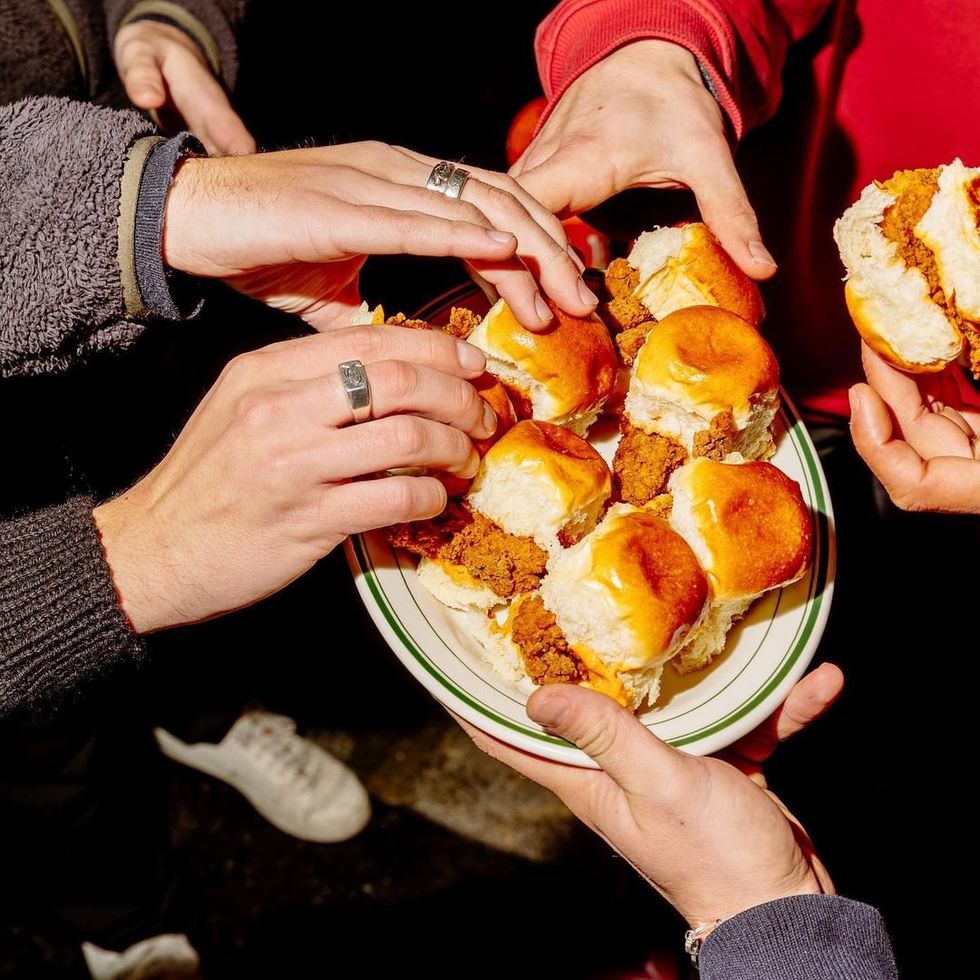 Customers sharing baby burgers filed with fried chicken.