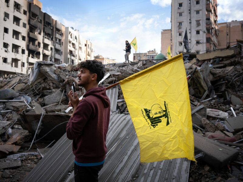 Dahiye, Lebanon: Two men hold Hezbollah flags over the ruins of a bombed building. At 4 a.m. local time, the ceasefire between Israel and Hezbollah came into effect after months of heavy fighting that killed at least 3,500 people and displaced 1.3 million.