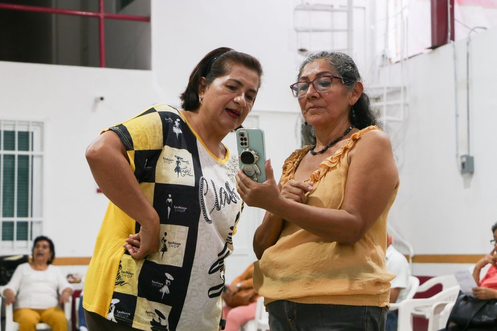 Danzón class participants Norma Angélica Guillén Villanueva, left, and Diana Trujillo Cruz study a video to perfect their choreography during rehearsals at the Guerrero Institute for the Comprehensive Care of Older Adults.