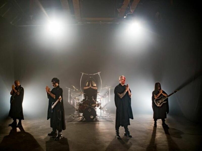 Death metal band Dharma on stage, praying.