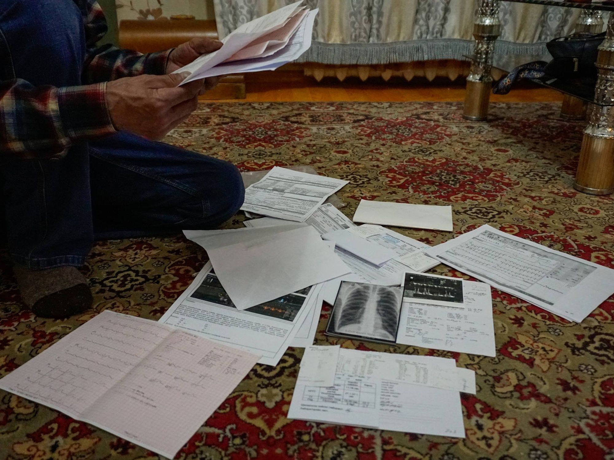 Delger Vangan, 65, reviews X-rays, electrocardiograms and other medical notes from his doctors at his home in the city of Erdenet.