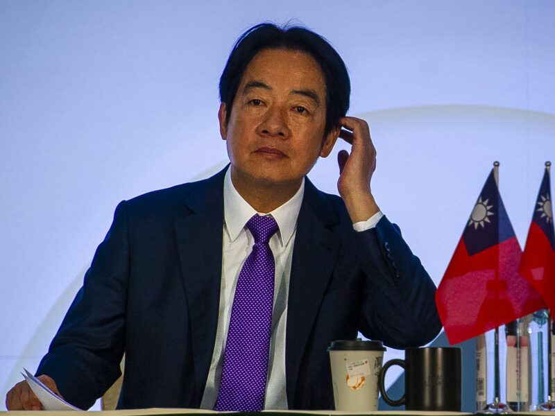 Democratic Progressive Party presidential candidate William Lai holding a press conference with the Taiwan flag in front of him and coffee cups.