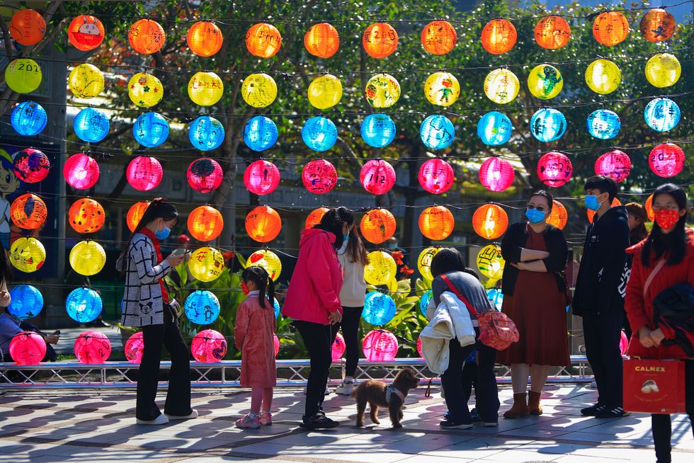Devotees are seen near a temple where colourful lanterns are displayed as they tribute to local gods and goddesses for healthy, prosperity, and harmony on the first day of the Lunar New Year.