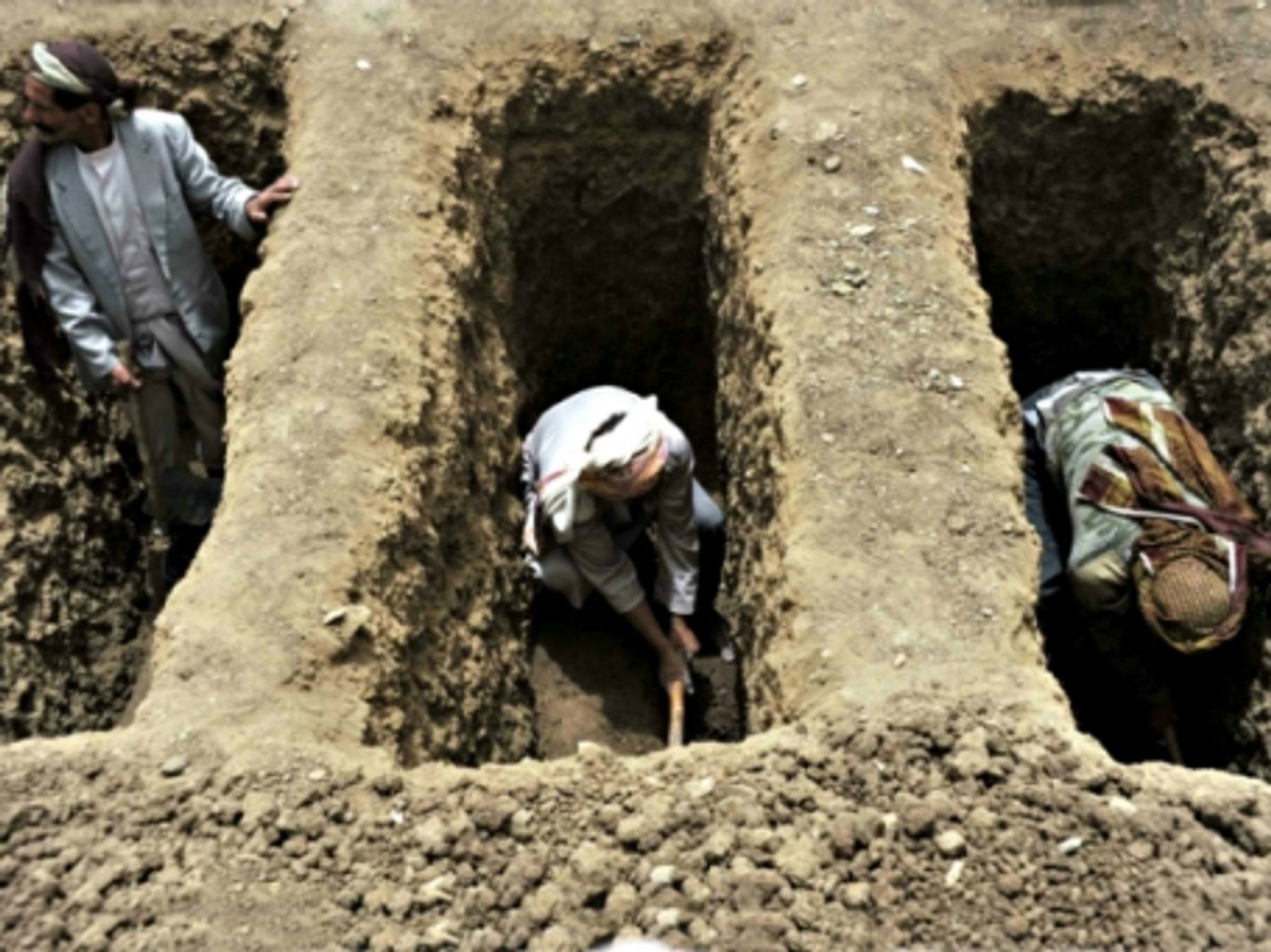 Digging graves after a Saudi airstrike in Yemen's Bani Matar district on April 4