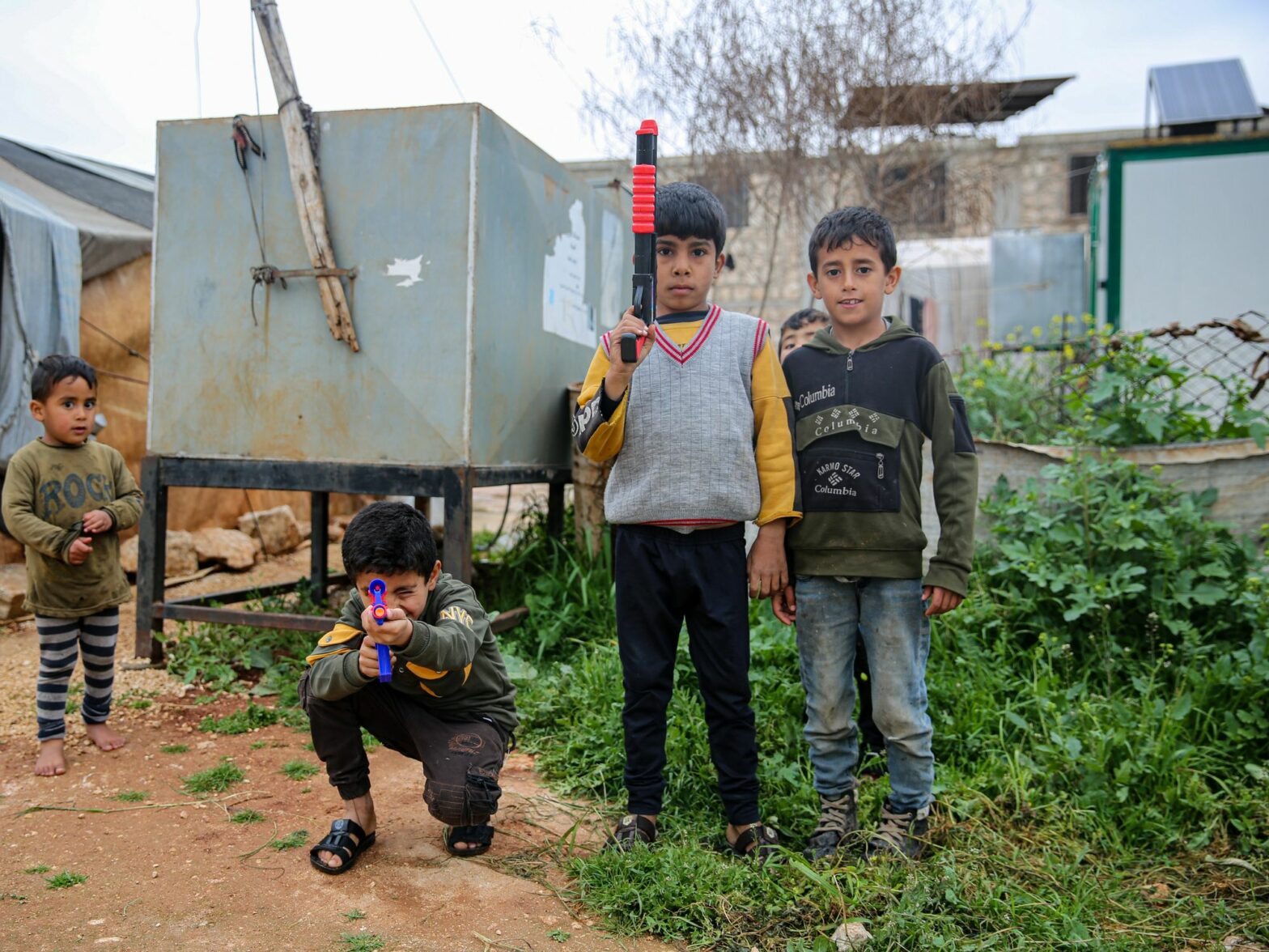 Displaced children play with toy guns in the make-shift camp of al-Bardaqli near Sarmada, northwest Syria.