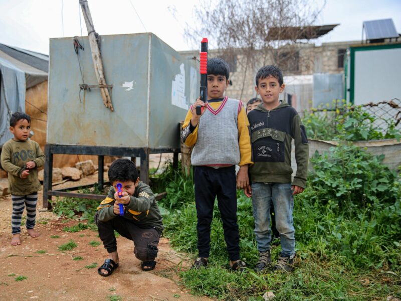 Displaced children play with toy guns in the make-shift camp of al-Bardaqli near Sarmada, northwest Syria.