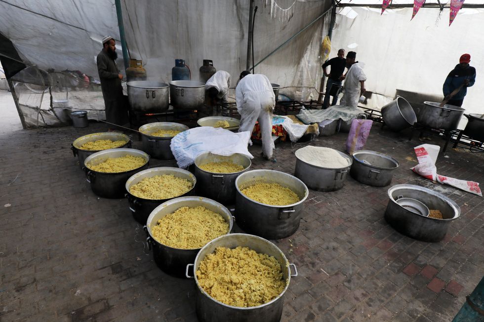Displaced Palestinians are collecting food donated by a charity before an iftar meal, the breaking of the fast, on the On the twenty-fourth day of the Muslim holy fasting month of Ramadan.
