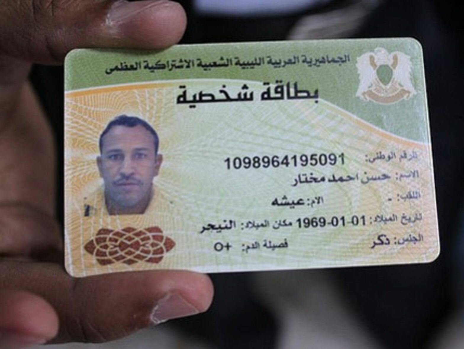 Doctors in Brega, Libya show identity card of a slain pro-Gaddafi fighter they say was a Tuareg from Niger