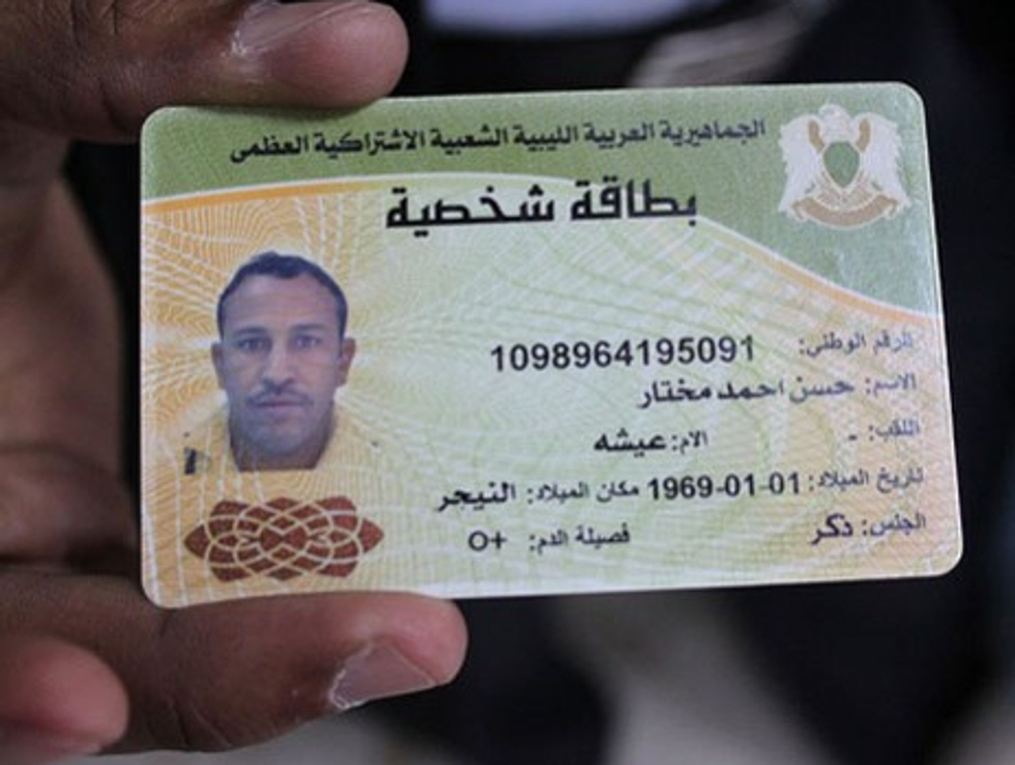 Doctors in Brega, Libya show identity card of a slain pro-Gaddafi fighter they say was a Tuareg from Niger