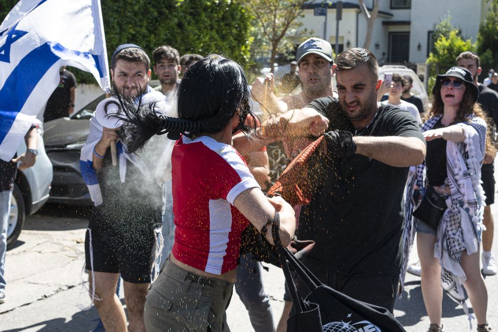 ​ A Pro-Palestine protester gets pepper sprayed and water thrown on her as a mob of Pro-Israeli protesters chase her down.