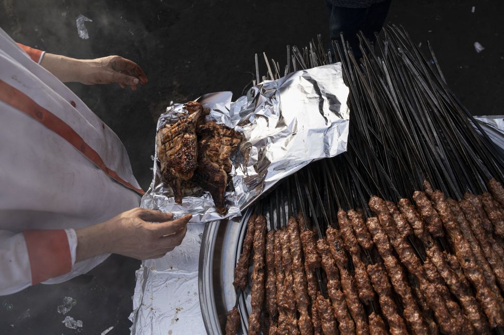 ​A chef prepares grilled chickens at a restaurant near Bab al-Futuh, a historical landmark in Cairo, during the holy month of Ramadan.